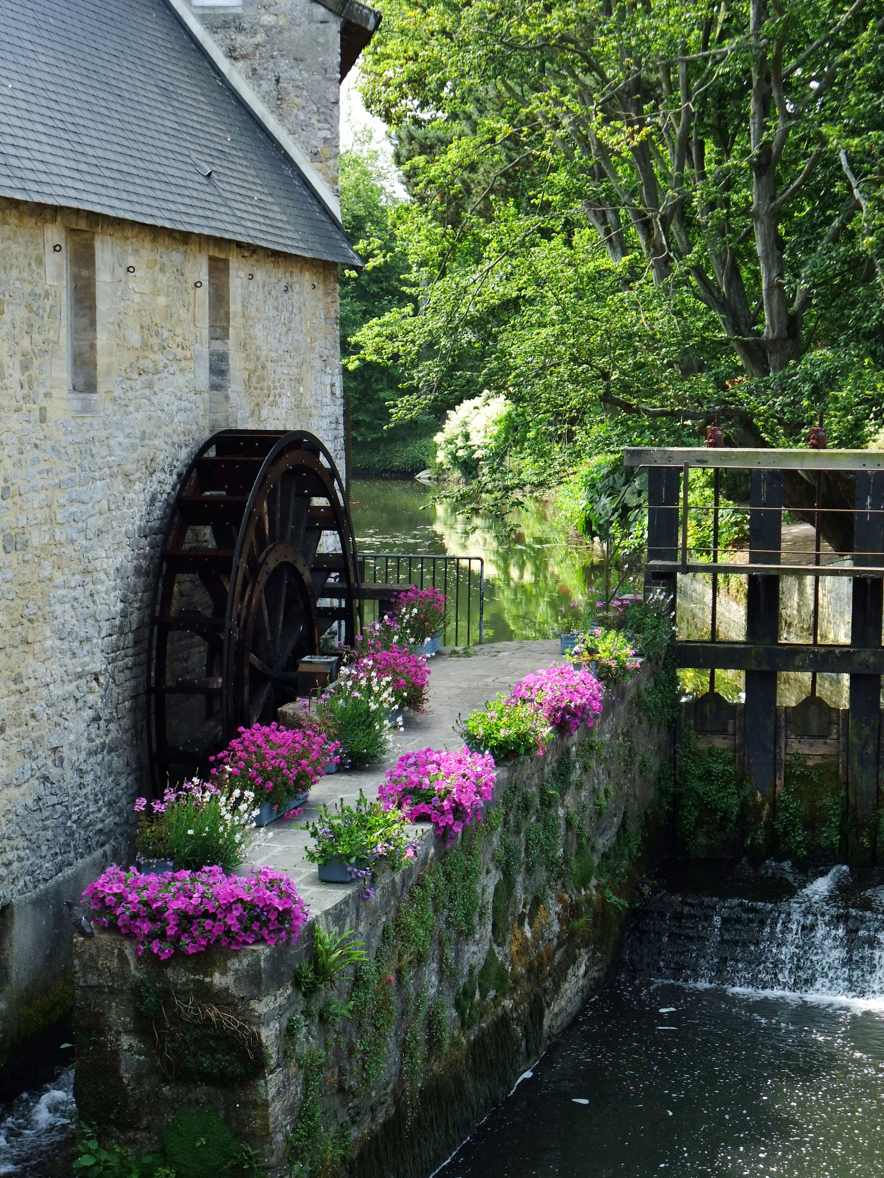 Old watermill and flowers beside the Aure River in Bayeux, Normandy, France